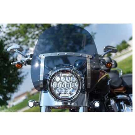 Motorcycle with a prominent headlight and windshield on a blurred natural background