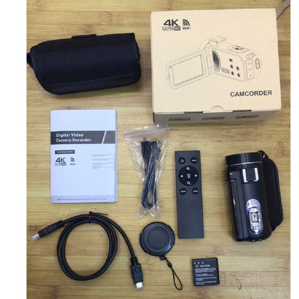 Digital video camera with accessories on a wooden surface