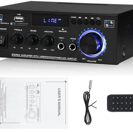 Black audio amplifier with control knobs and display, accompanied by a user manual, cable, and remote control on a white background.