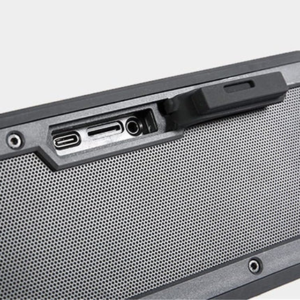 Close-up of a portable speaker with connectivity ports on a light gray background