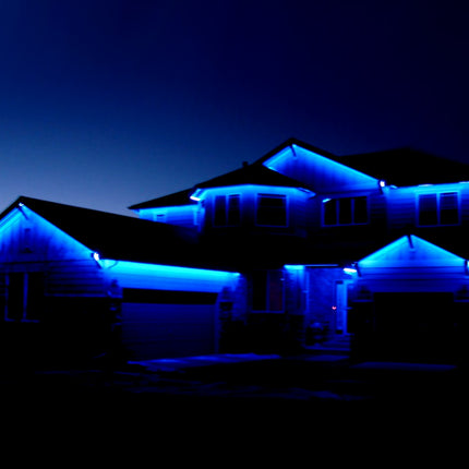 House illuminated with blue lights against a dark sky