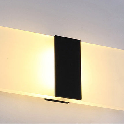 Modern wall-mounted light fixture with a black central panel on a plain background