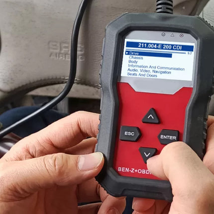 Car diagnostic tool being used on a vehicle with a screen displaying diagnostic information.