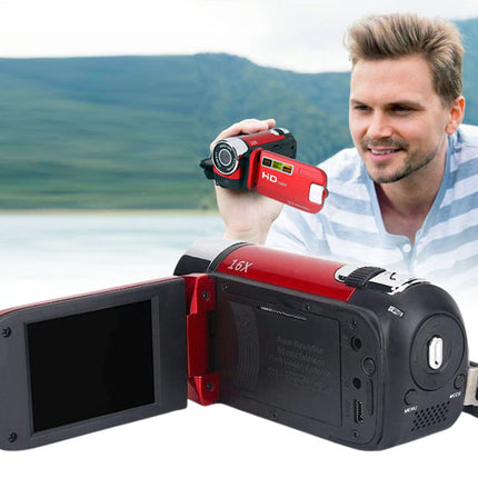 A red and black digital video camera with its screen open, shown in front of a man holding a smaller matching camera, with a blurred outdoor landscape background.