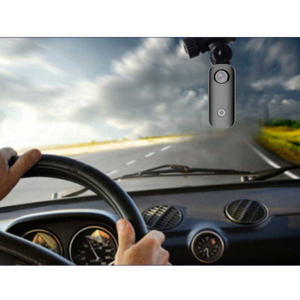 Car dashboard with a driver holding the steering wheel, and a dashcam mounted on the windshield.