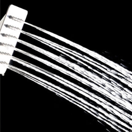 Close-up of a shower head with water flowing against a black background