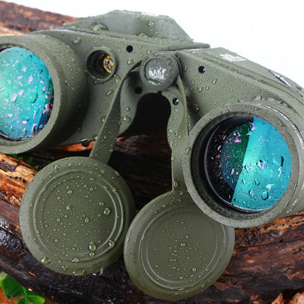 Green binoculars with water droplets on lenses placed on a wooden surface